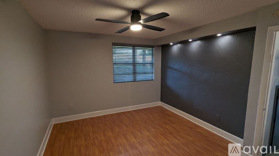 A room with a ceiling fan and a window with blinds.