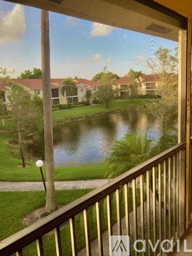A view from a balcony overlooking a pond and houses.