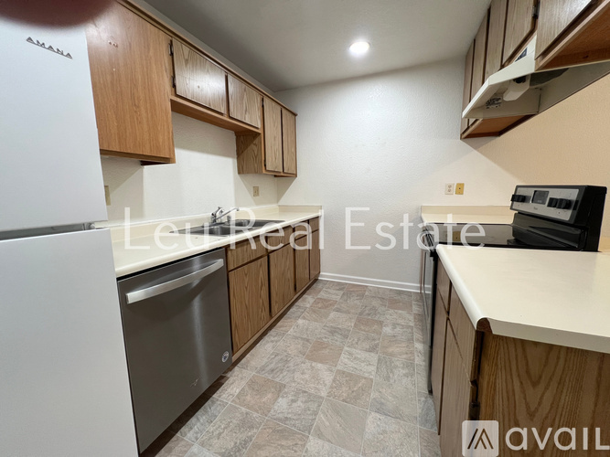 A kitchen with a white fridge and wooden cabinets.