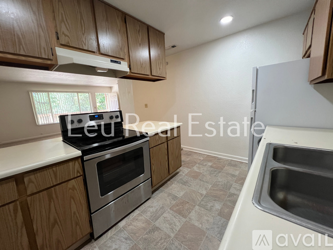A kitchen with wooden cabinets and a stove top oven.