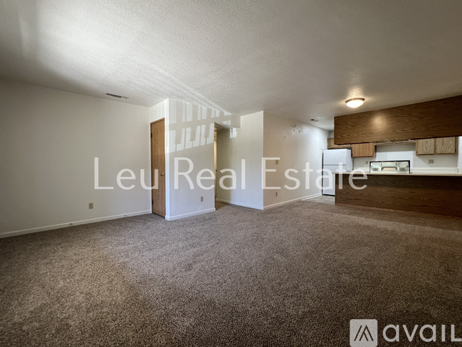 A carpeted room with a doorway leading to another room.