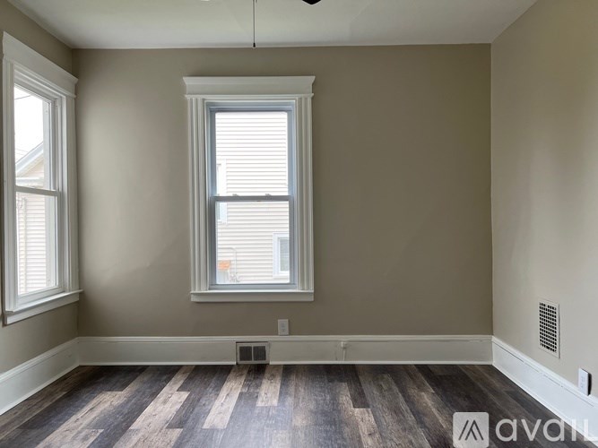 A room with a window and wooden flooring.