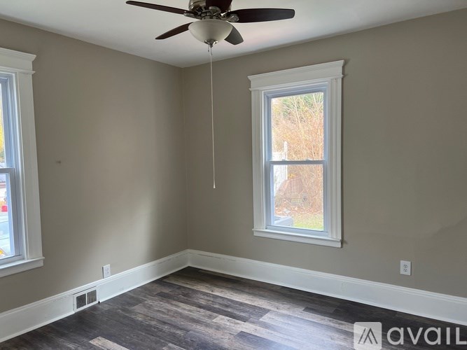 A room with a ceiling fan and a window.