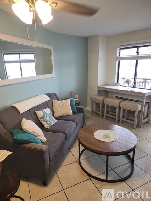 A living room with a grey couch and a wooden coffee table.