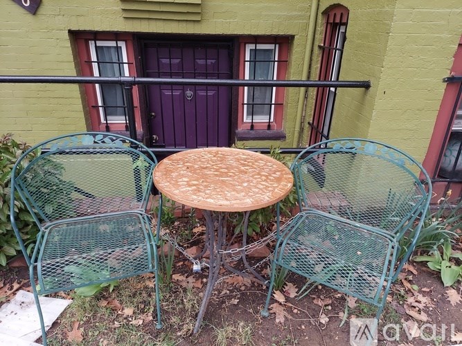 A small table and two chairs are set up on a patio.