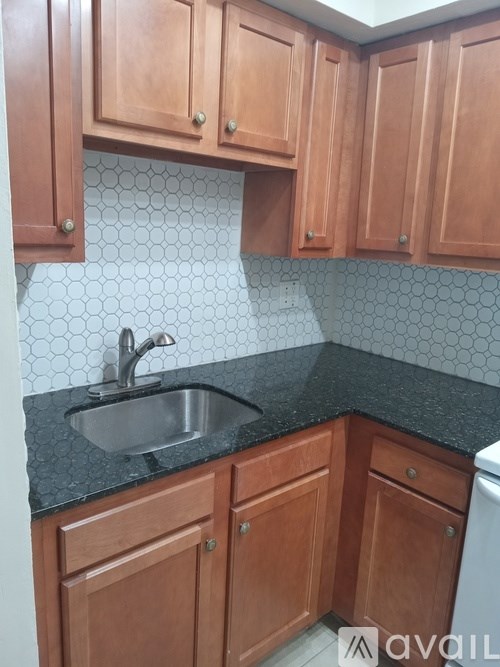 A kitchen with wooden cabinets and a black counter top.