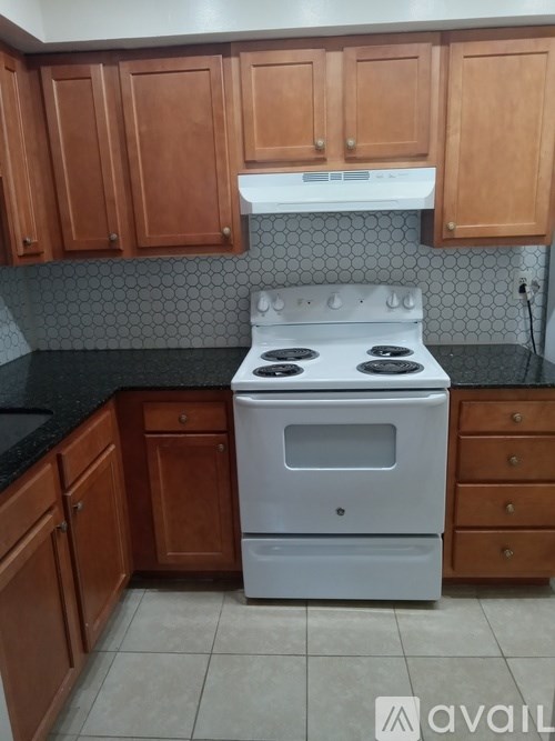 A white stove in a kitchen with wooden cabinets.