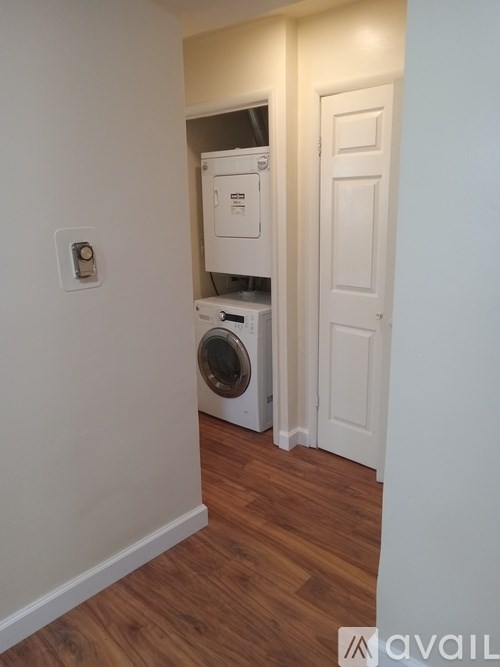 A small room with a washing machine and a door.