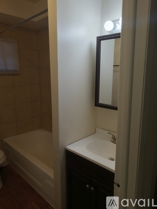A bathroom with a white sink and a bathtub.