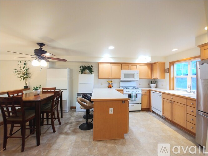 A kitchen with wooden cabinets and a dining table with chairs.