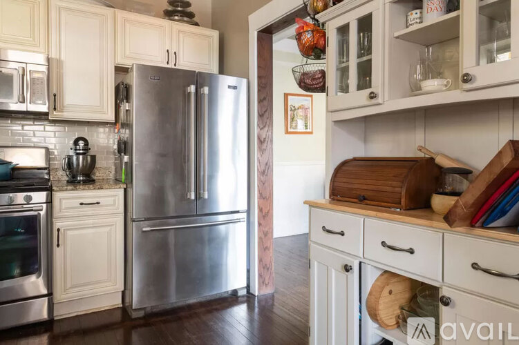 A kitchen with a refrigerator, oven, and cabinets.