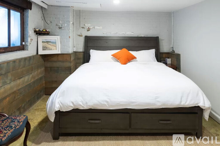 A bedroom with a large bed and a wooden headboard.