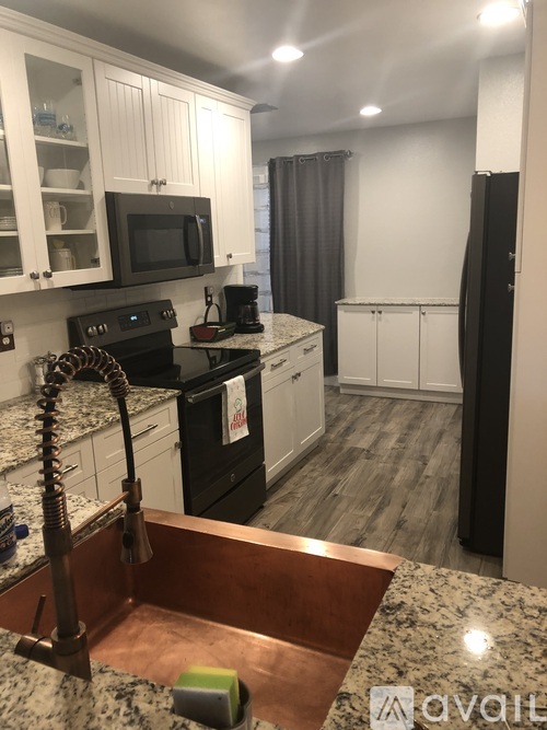 A kitchen with a black oven and a microwave above it.
