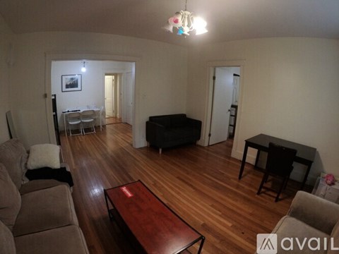 A living room with a couch, a coffee table, and a television.