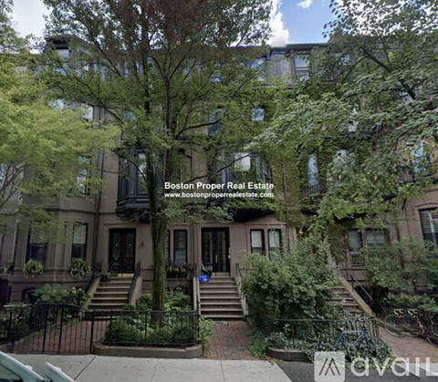 A building with a tree in front of it and a website address on the tree.