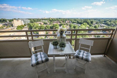 a balcony with a table and chairs and a view of the city