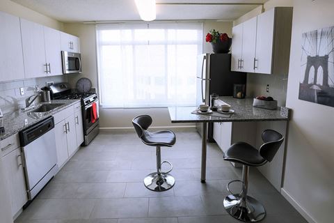 a kitchen with white cabinets and a table with chairs