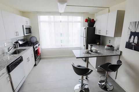 a kitchen with white cabinets and a counter top and a sink