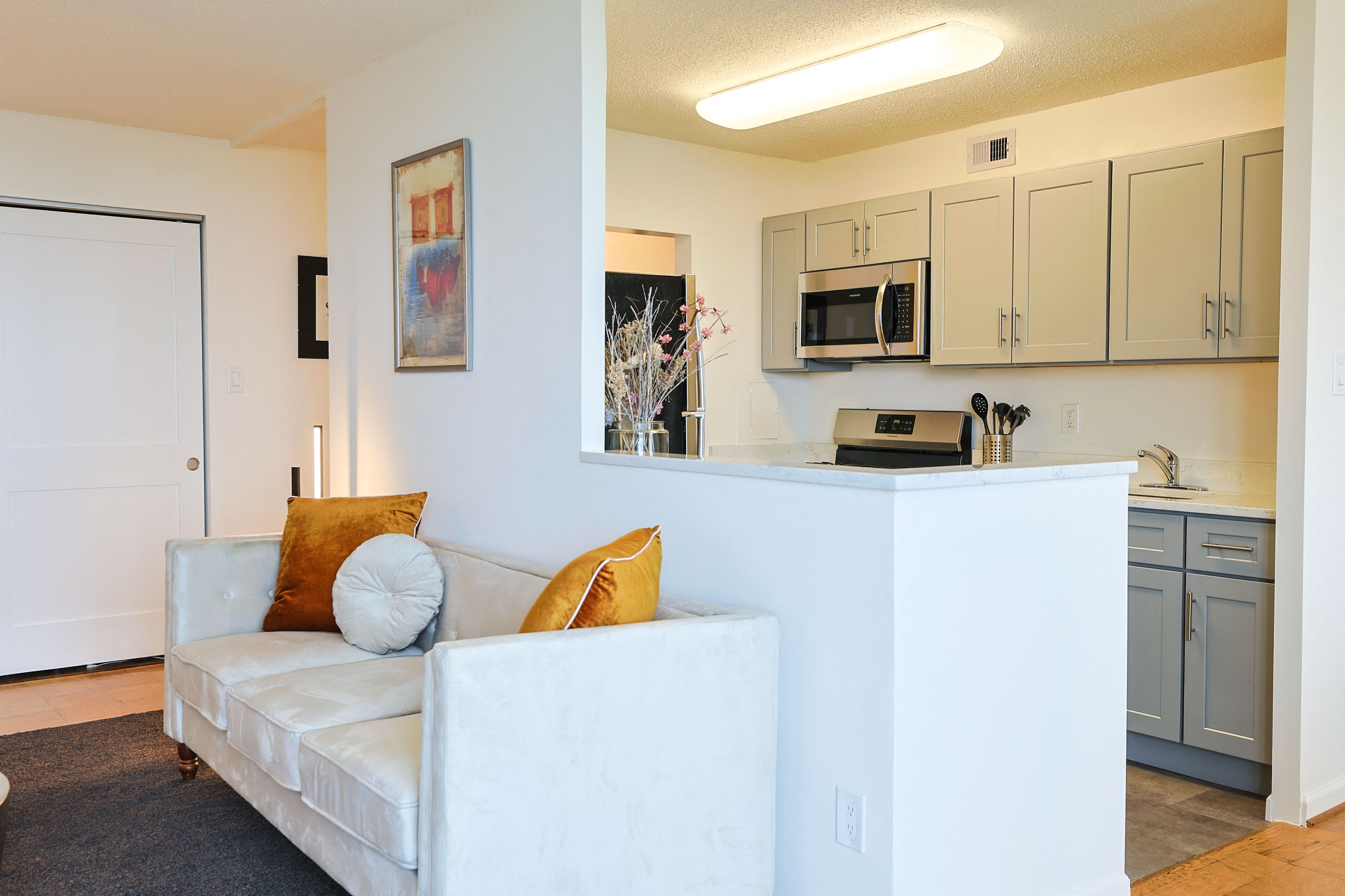 a living room with a couch and a kitchen