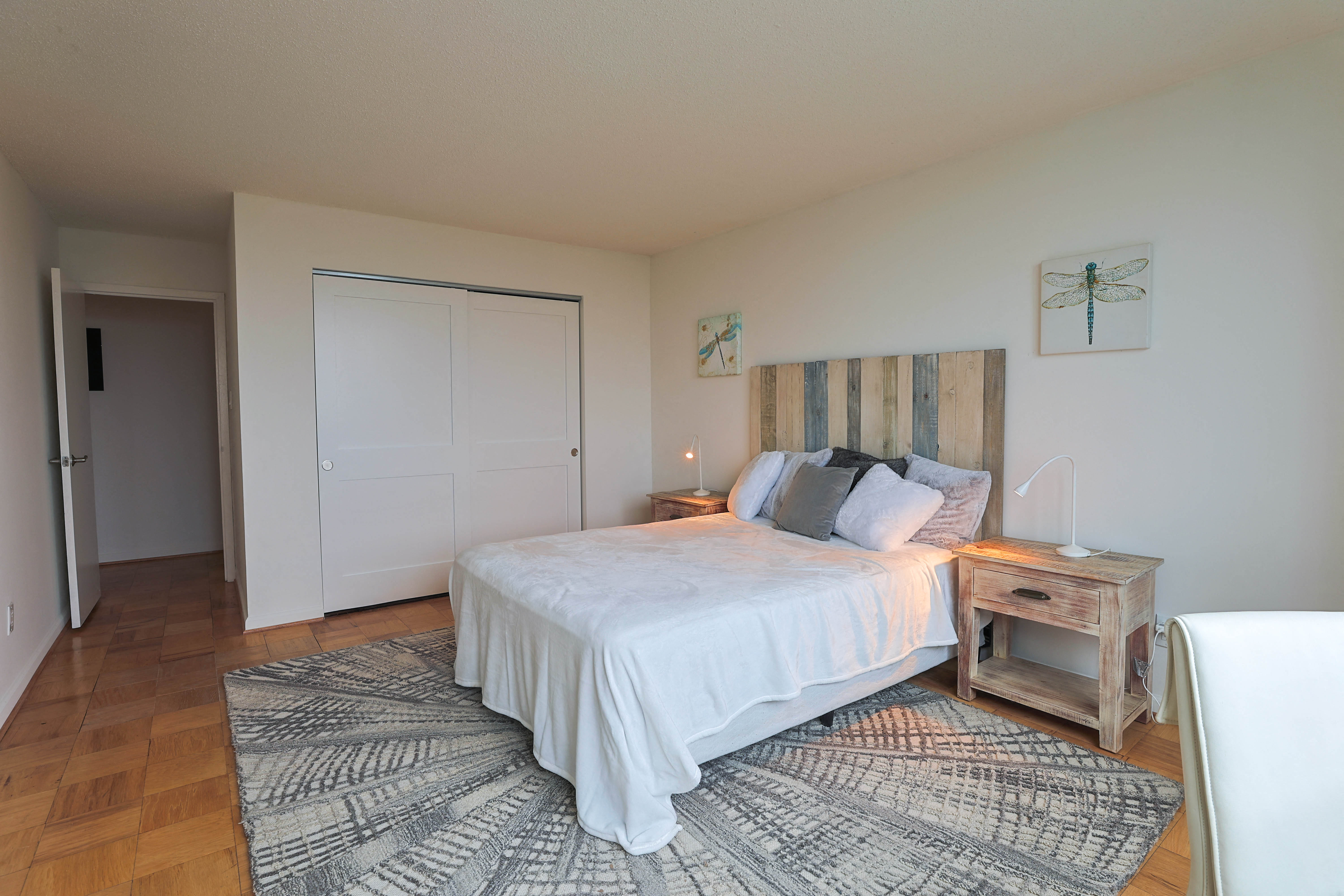 a bedroom with a white bed and a wooden headboard