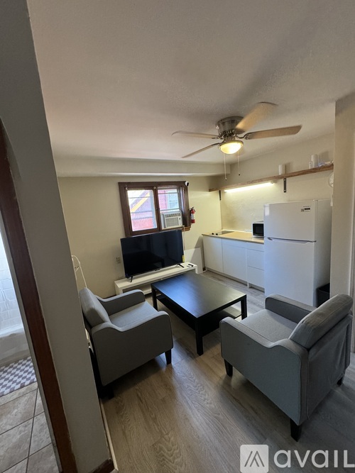 A living room with a couch, chair, and a television.