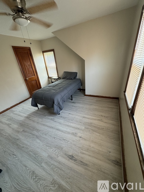 A bedroom with a bed and a ceiling fan.