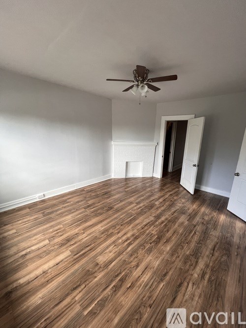 A room with wooden flooring and a ceiling fan.