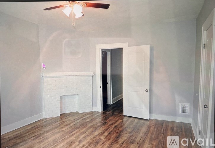 A room with a fireplace and a ceiling fan.