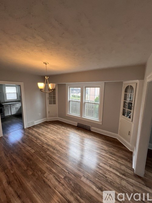 A room with wooden floors and a chandelier.
