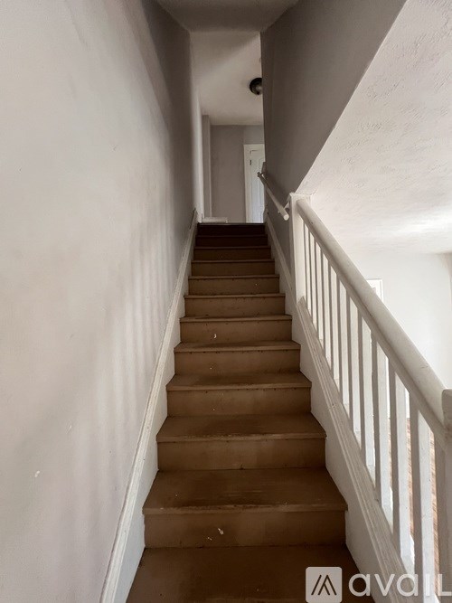 A staircase with white railings and brown steps.