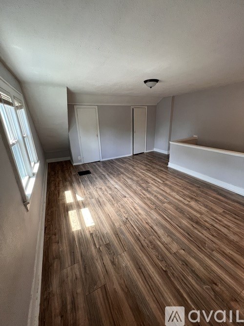 A room with wooden flooring and white walls.