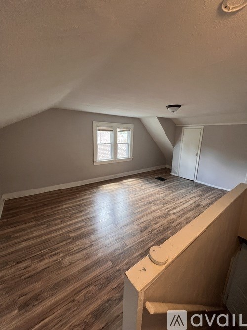 A room with wooden flooring and a window.