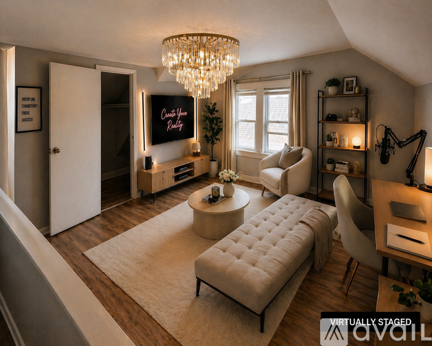 A living room with a couch, a coffee table, a TV, and a chandelier.