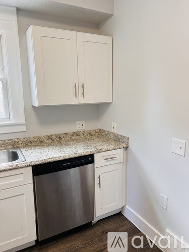 A kitchen with white cabinets and a granite countertop.