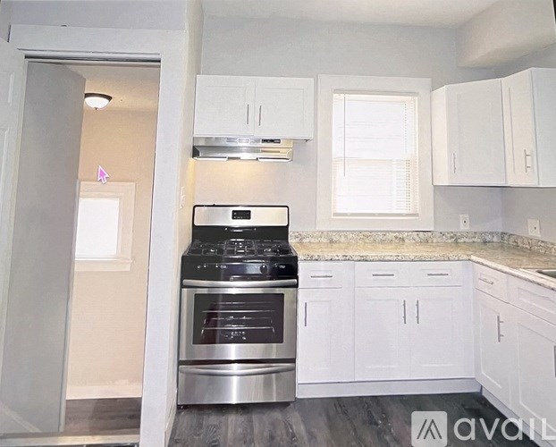A kitchen with white cabinets and a stainless steel oven.