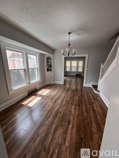 A room with wooden floors and a chandelier.