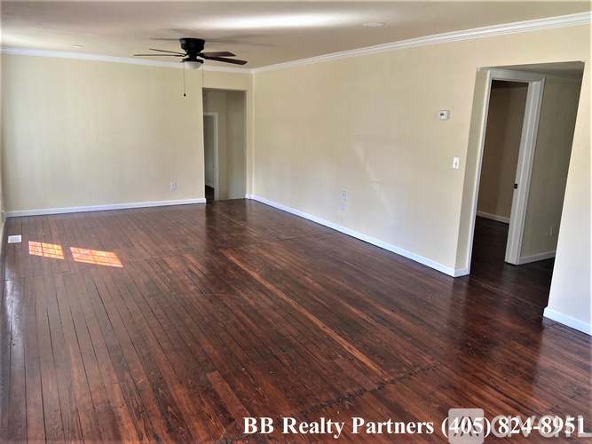A room with wooden floors and a ceiling fan.