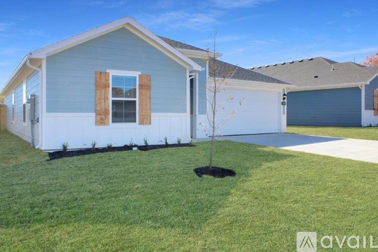 A house with a small tree in the front yard.