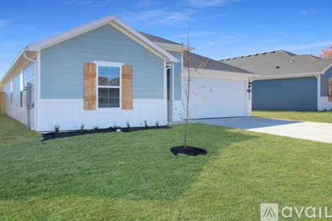 A house with a small tree in the front yard.