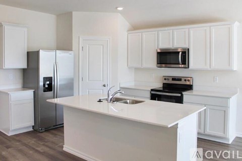 A kitchen with white cabinets and appliances.