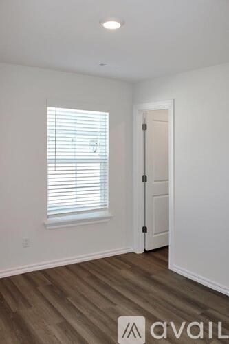 A room with a window and wooden flooring.