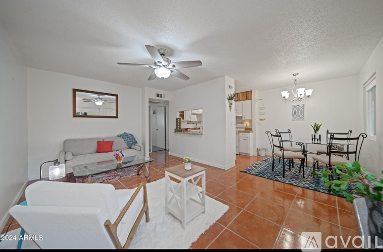 A living room with a white couch and a fan on the ceiling.