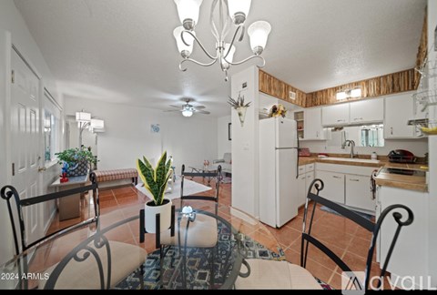 A kitchen with a dining table and chairs.
