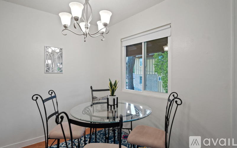 A dining room with a glass table and chairs.