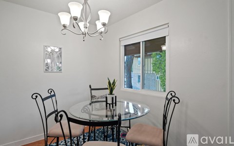 A dining room with a glass table and chairs.