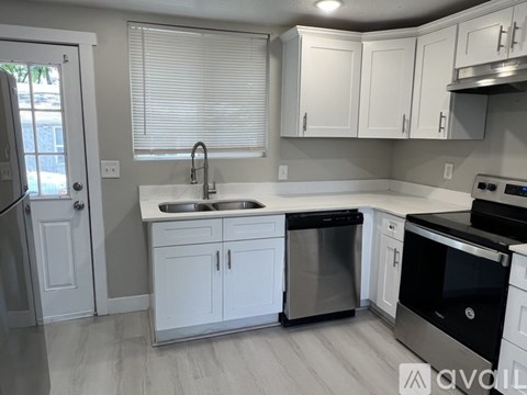 A kitchen with white cabinets and stainless steel appliances.