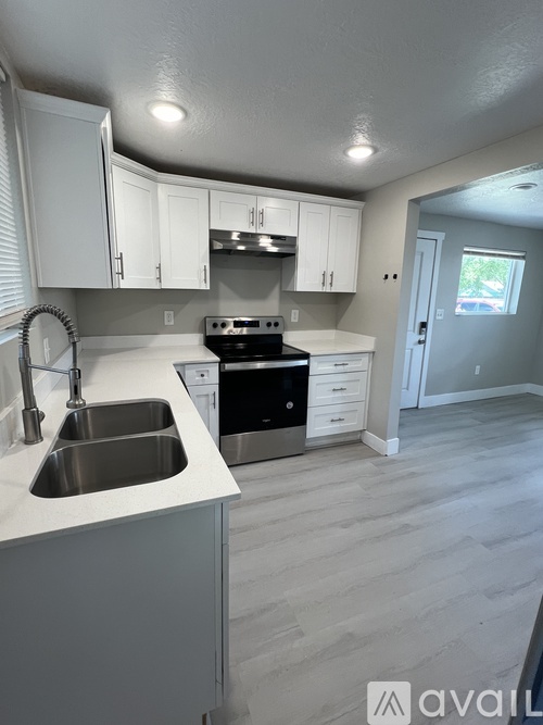 A kitchen with white cabinets and a stainless steel sink.