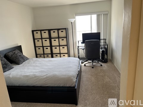 A bedroom with a bed, desk, and chair.
