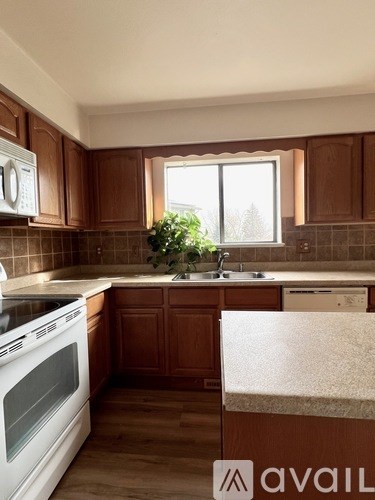 A kitchen with wooden cabinets and a white oven.