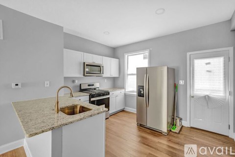 A kitchen with a granite countertop and stainless steel appliances.